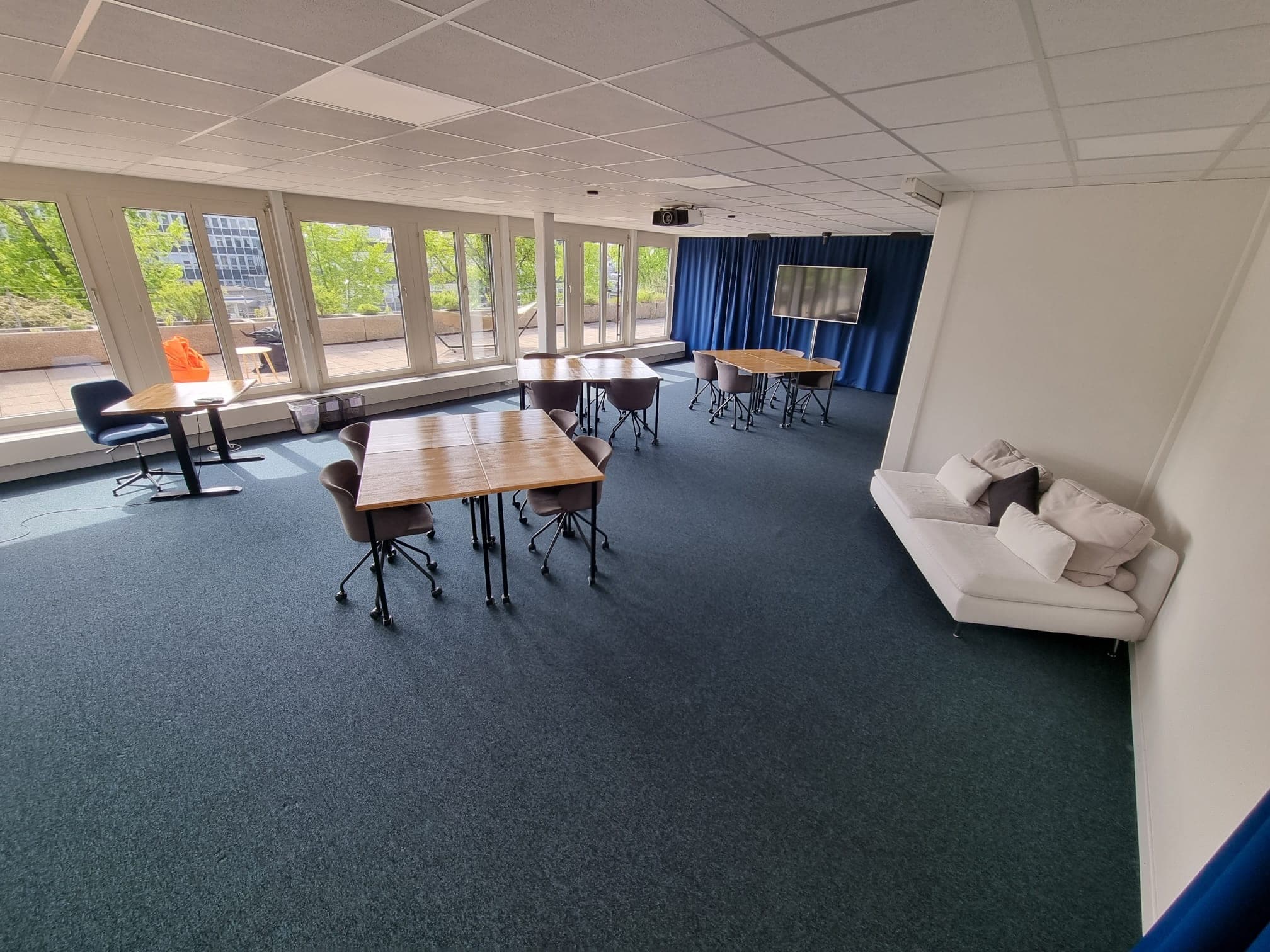 Tables individuelles et coin salon dans la salle Quilles